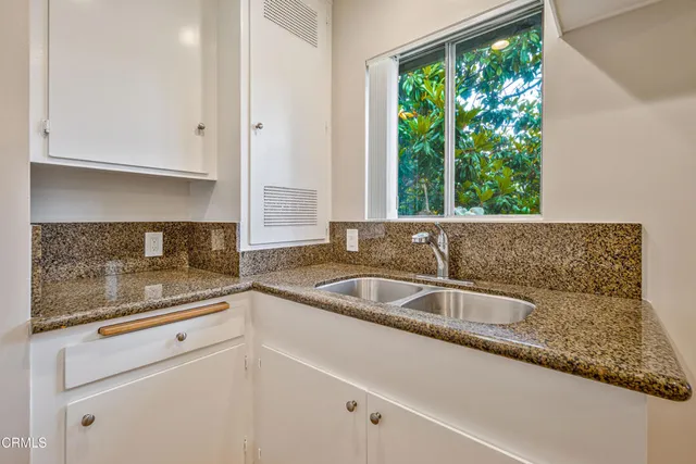 a view white cabinets with a sink and dishwasher