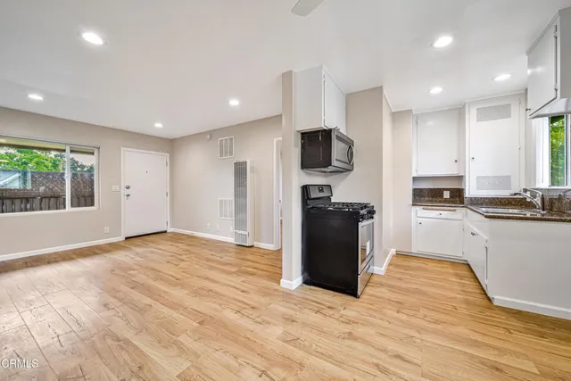 a large kitchen with stainless steel appliances granite countertop a stove a sink and a refrigerator