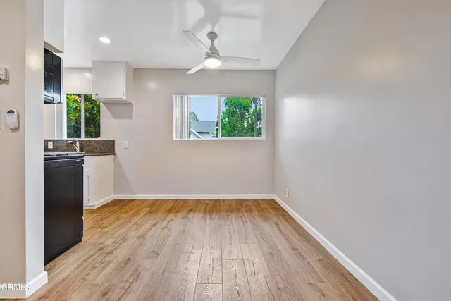 a view of a kitchen with wooden floor and a window