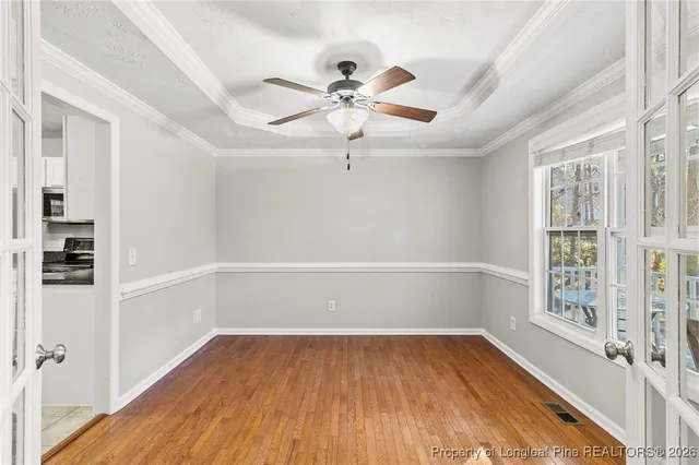 a view of an empty room with a window and wooden floor