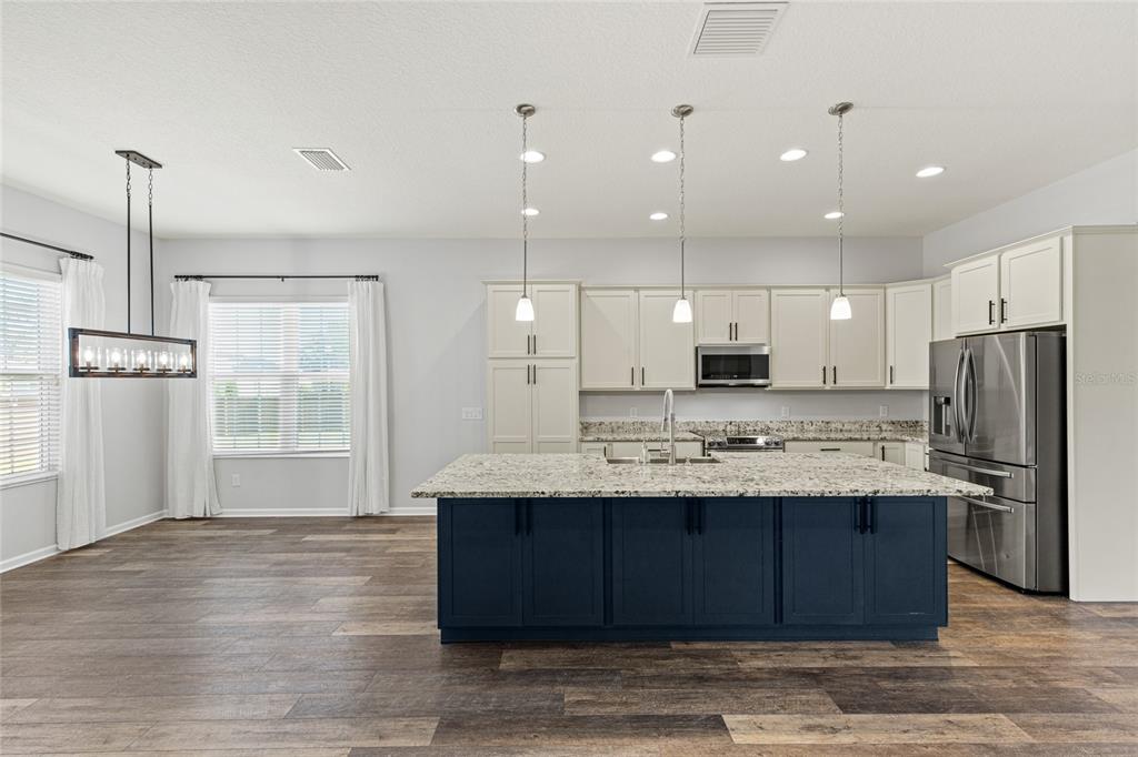 11202 Roz Way Oxford, FL 34484 - Photo 13 of 44 a kitchen with kitchen island a sink stainless steel appliances and refrigerator