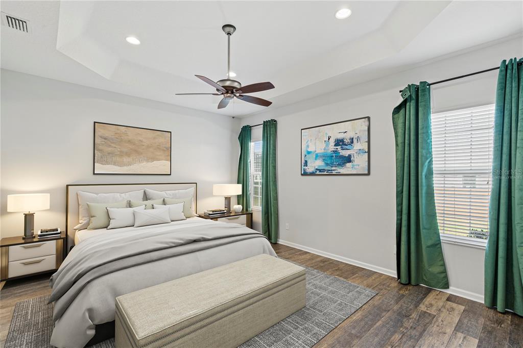 11202 Roz Way Oxford, FL 34484 - Photo 20 of 44 a bedroom with a large bed and a chandelier