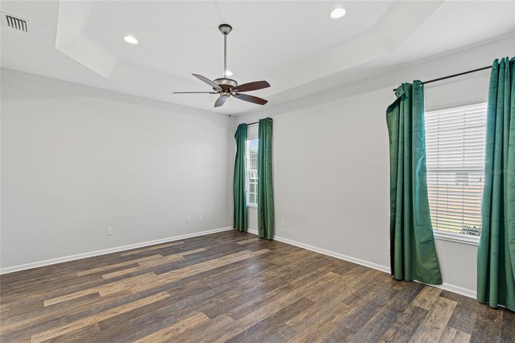 11202 Roz Way Oxford, FL 34484 - Photo 21 of 44 a view of an empty room with a window and wooden floor