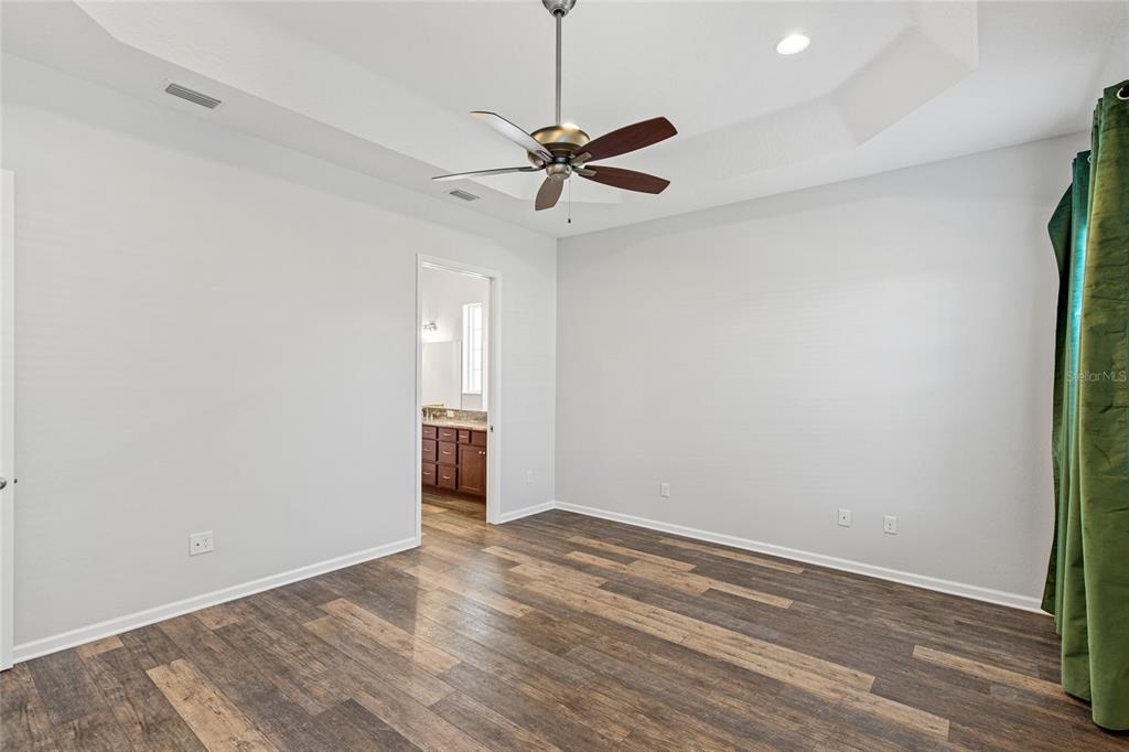 11202 Roz Way Oxford, FL 34484 - Photo 22 of 44 a view of a room with wooden floor and a ceiling fan