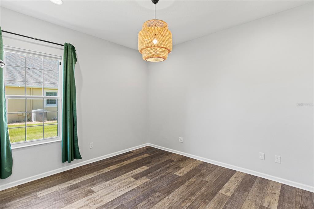 11202 Roz Way Oxford, FL 34484 - Photo 32 of 44 an empty room with wooden floor and windows