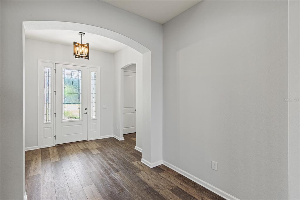 11202 Roz Way Oxford, FL 34484 - Photo 8 of 44 an empty room with wooden floor and windows