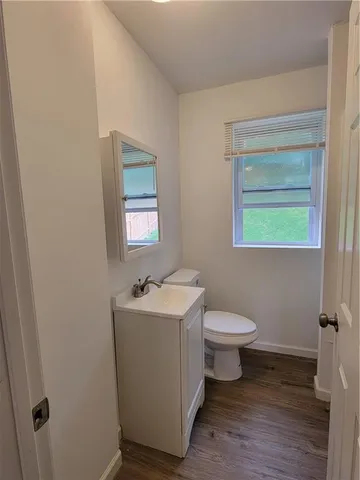 a bathroom with a toilet sink vanity and mirror