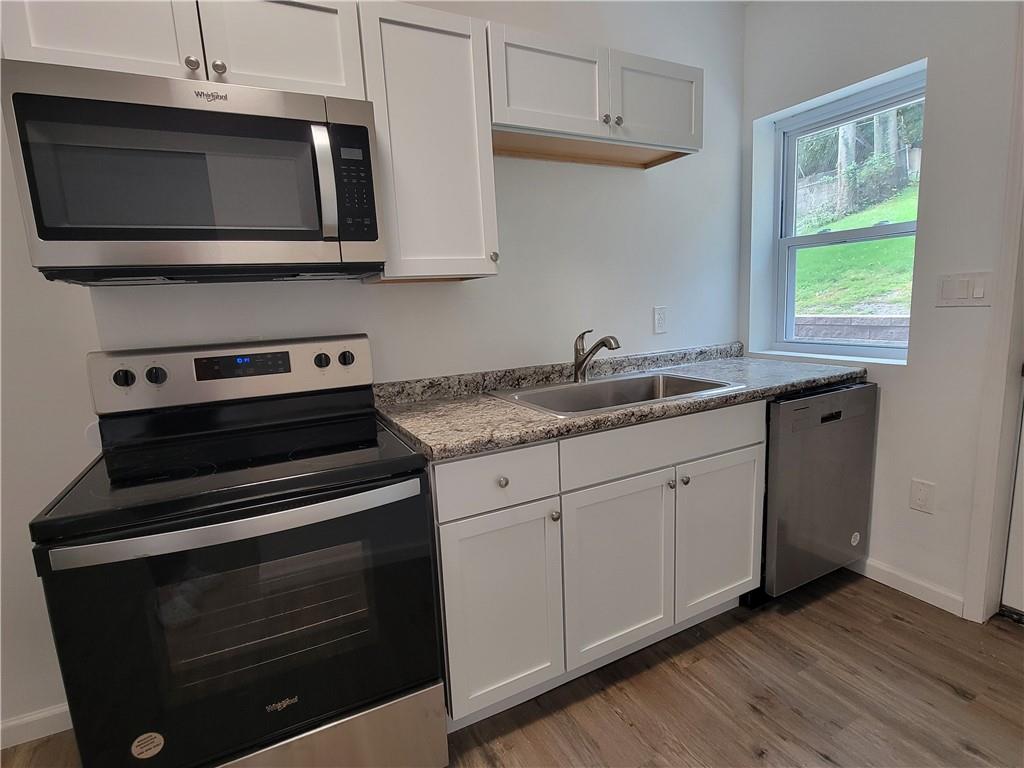 518 5th Avenue Coraopolis, PA 15108 - Photo 7 of 18 a kitchen with stainless steel appliances granite countertop a stove microwave and sink