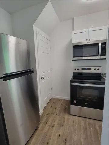a kitchen with wooden floor and a stove top oven