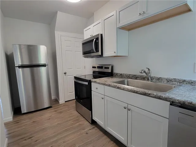 a kitchen with sink a microwave and refrigerator