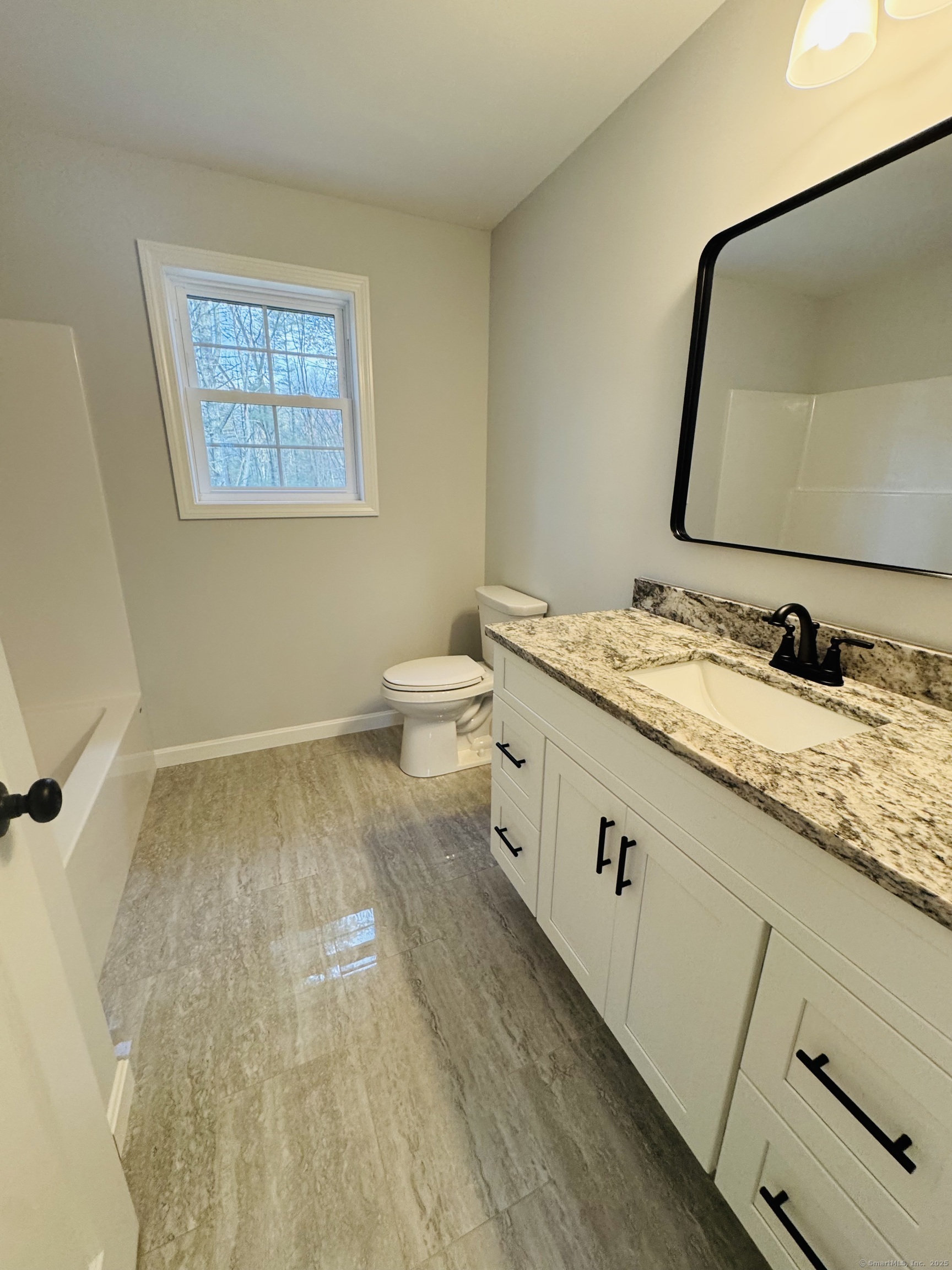 160 Ross Road Brooklyn, CT 06234 - Photo 11 of 13 a spacious bathroom with a granite countertop sink and a mirror