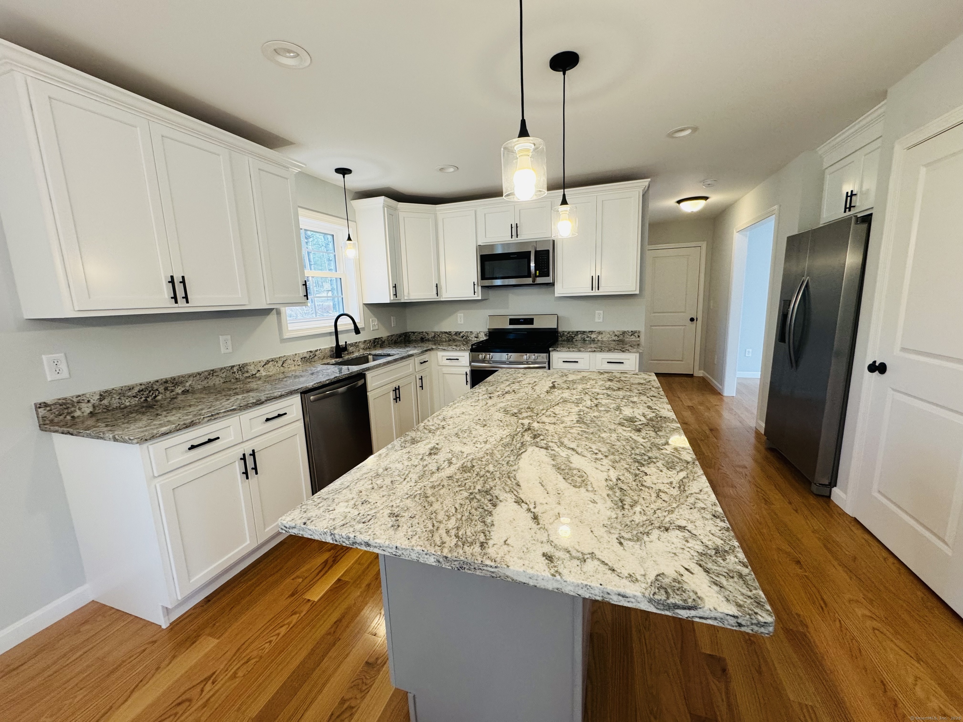 160 Ross Road Brooklyn, CT 06234 - Photo 2 of 13 a large kitchen with kitchen island granite countertop a sink a stove a refrigerator and white cabinets