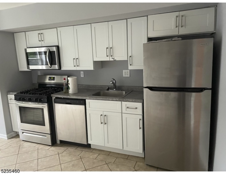 a kitchen with stainless steel appliances granite countertop a refrigerator sink and cabinets
