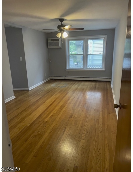 357 Franklin Street, Unit 5 Bloomfield, NJ 07003 - Photo 2 of 4 an empty room with wooden floor and windows