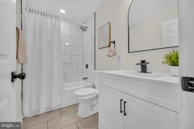 a bathroom with a sink a toilet a mirror and shower