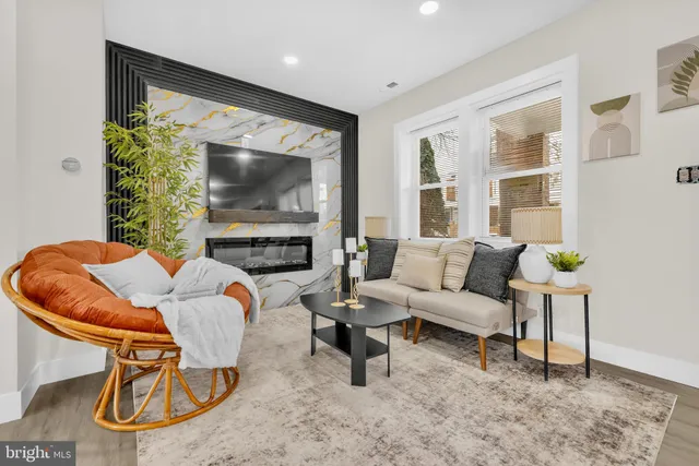 a living room with furniture a flat screen tv and a large window