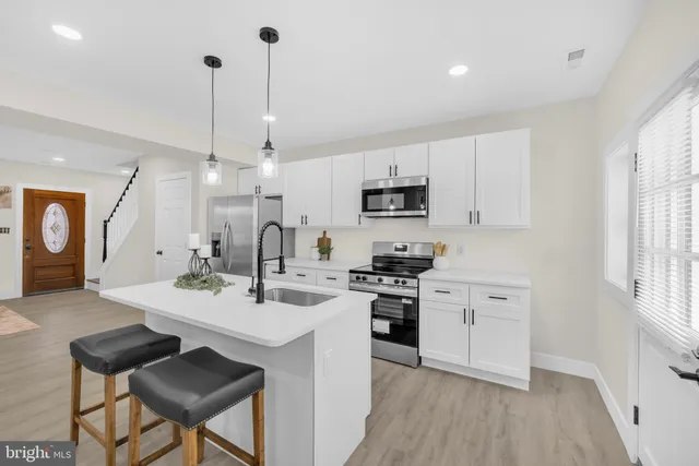 a kitchen with kitchen island granite countertop a sink a center island and cabinets