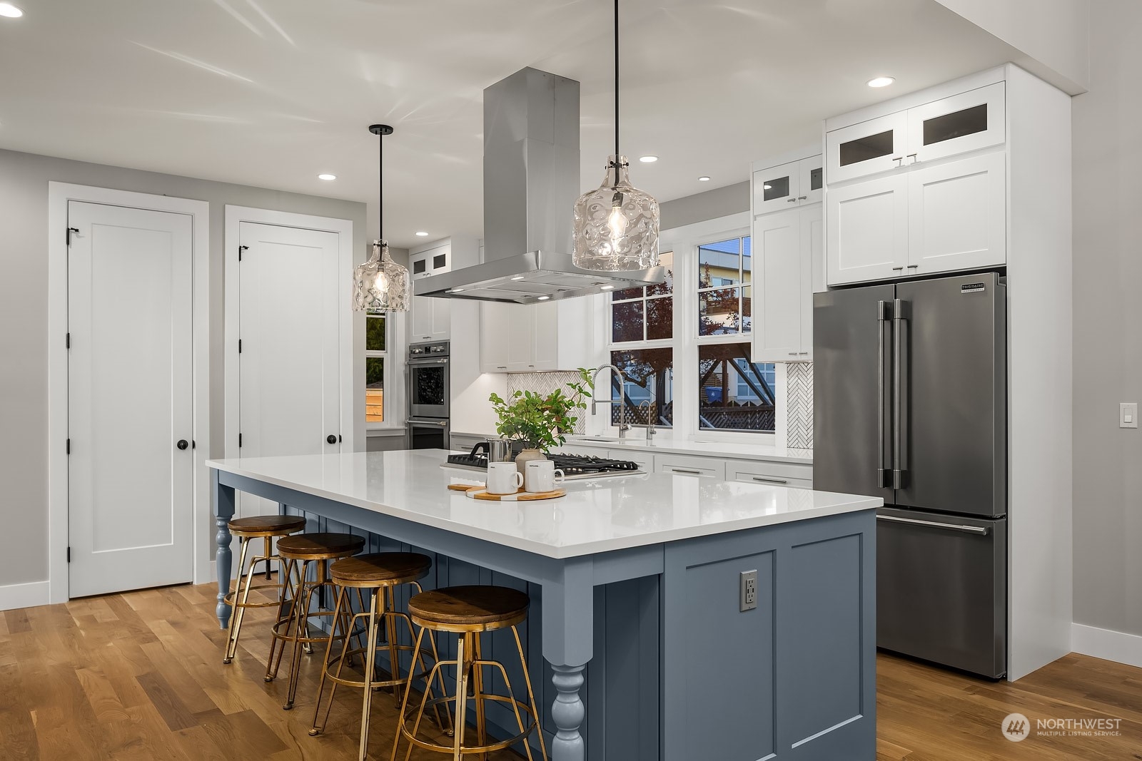 706 North 76th Street Seattle, WA 98103 - Photo 11 of 38 a kitchen with stainless steel appliances granite countertop a refrigerator a sink dishwasher a stove and a dining table with wooden floor