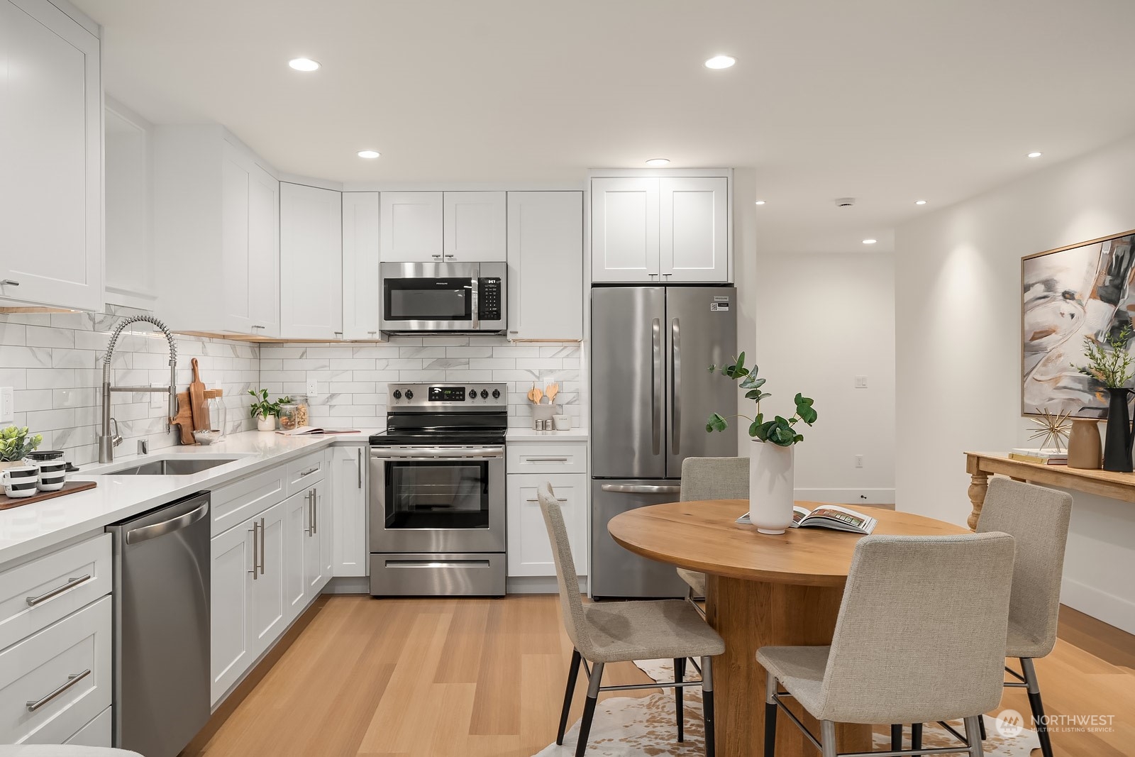 706 North 76th Street Seattle, WA 98103 - Photo 31 of 38 a kitchen with stainless steel appliances a stove a sink a refrigerator and a dining table