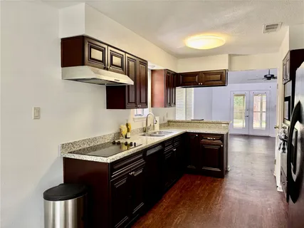 a kitchen with stainless steel appliances a sink cabinets and wooden floor