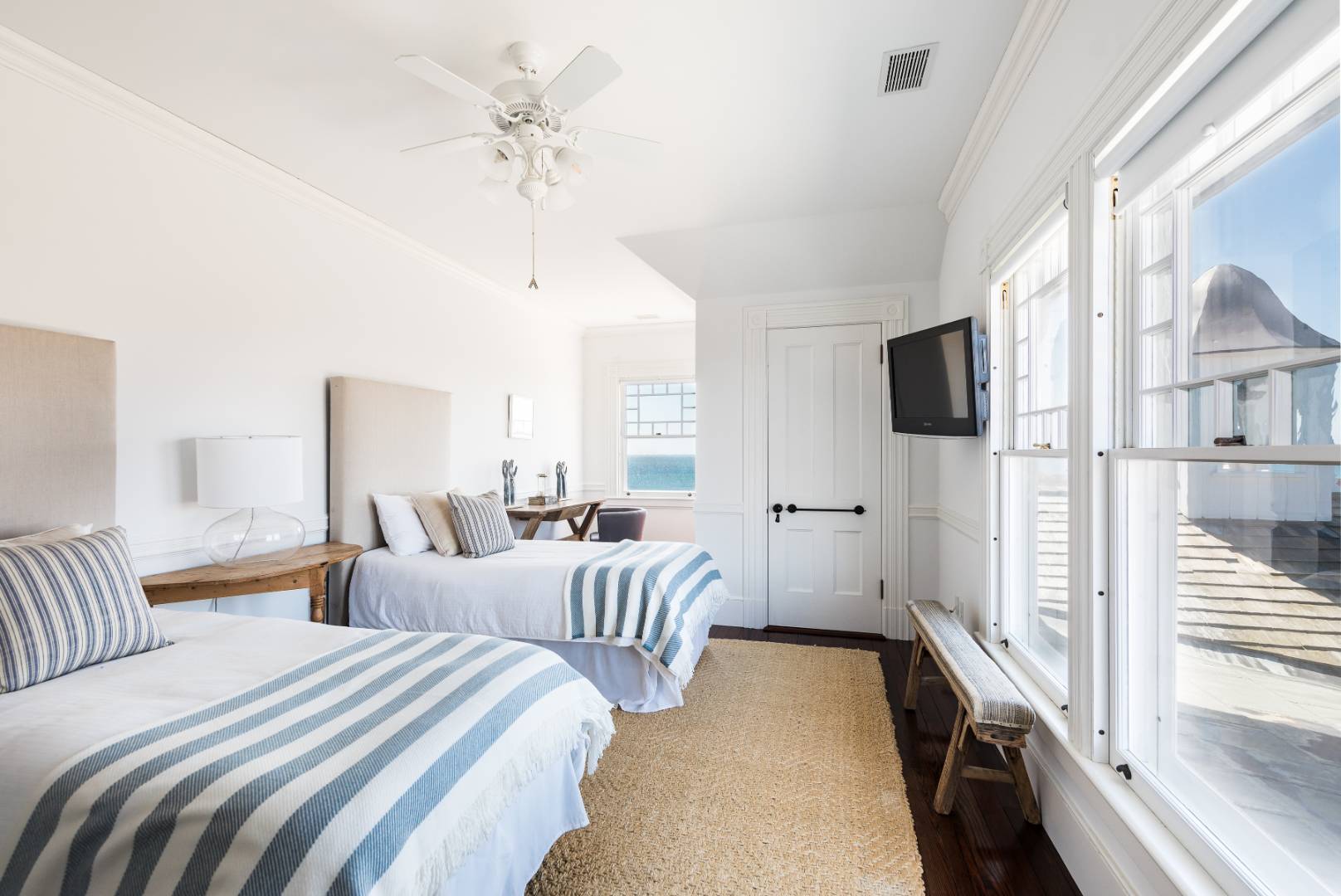 176 Deforest Road Montauk, NY 11954 - Photo 20 of 37 a bedroom with two beds and a chandelier