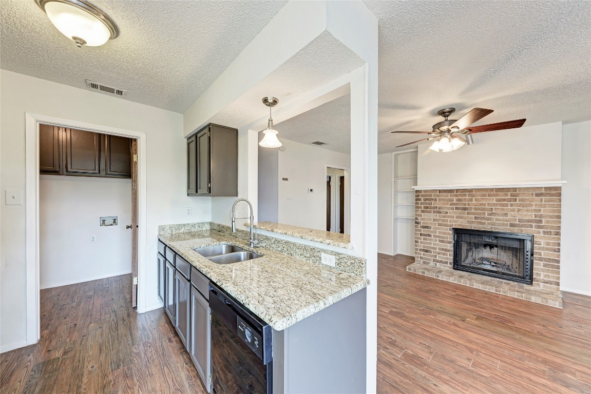 2106 Nickerson Street, Unit 203 Austin, TX 78704 - Photo 11 of 38 a kitchen with a granite countertop sink cabinets and wooden floor