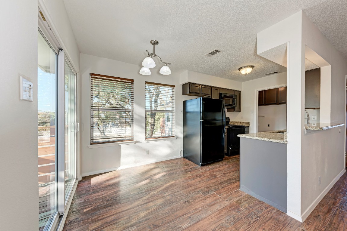 2106 Nickerson Street, Unit 203 Austin, TX 78704 - Photo 9 of 38 a kitchen with refrigerator a microwave and wooden floor