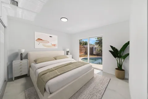 a bedroom with a large bed and a potted plant