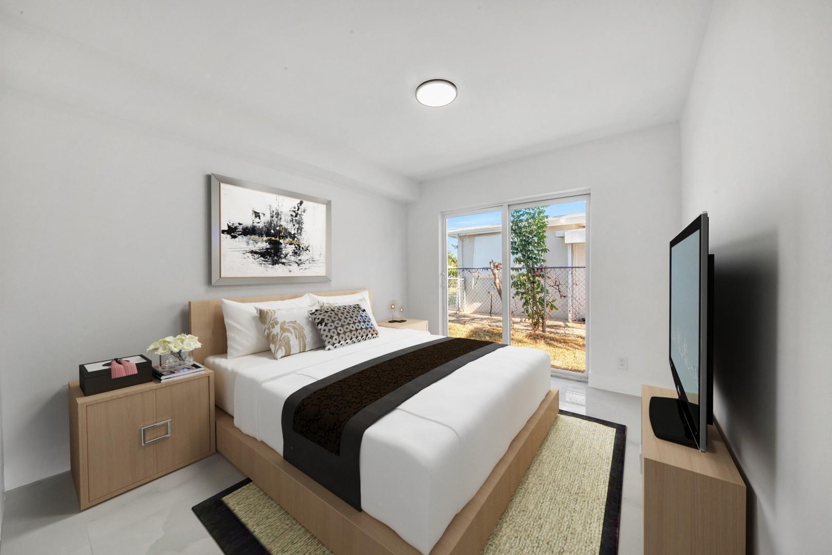 120 Northeast 57th Court Oakland Park, FL 33334 - Photo 14 of 20 a bedroom with a bed and a large mirror