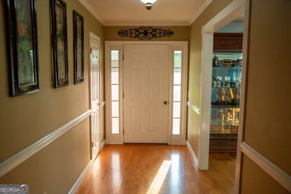 a view of a hallway with wooden floor and staircase