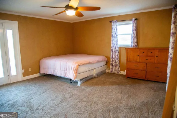 a spacious bedroom with a bed and a dresser