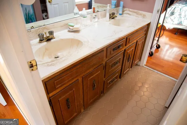 a bathroom with a double vanity sink a mirror and bathtub