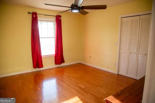 an empty room with a window and a ceiling fan