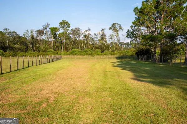 a view of a yard with swimming pool and trees