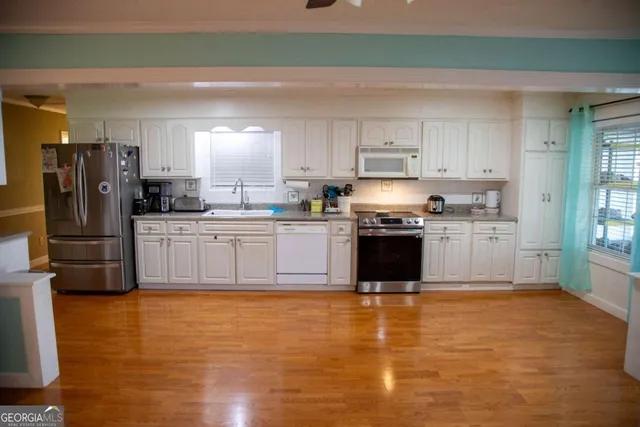 a kitchen with stainless steel appliances granite countertop a stove top oven sink and cabinets