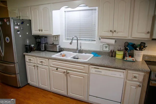 a kitchen with white cabinets and refrigerator