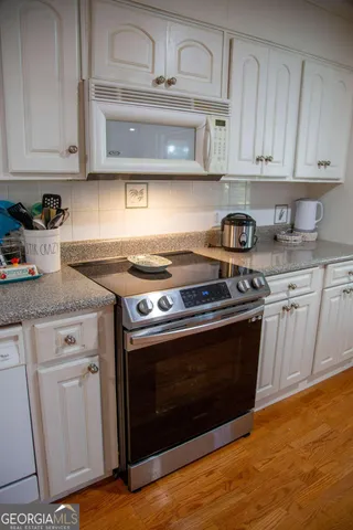 a stove top oven sitting inside of a kitchen