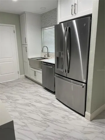 a kitchen with granite countertop a refrigerator and a sink