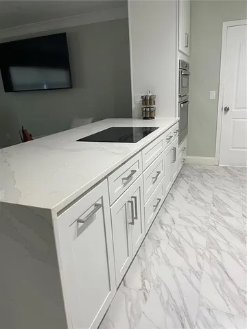 a kitchen with granite countertop white cabinets and sink