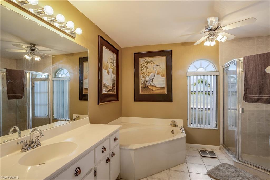 17509 Allentown Road Fort Myers, FL 33967 - Photo 11 of 20 a spacious bathroom with a bathtub a sink and a mirror