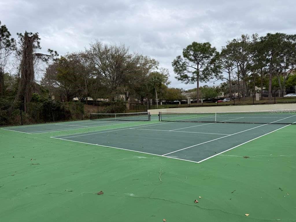 199 Afton Square, Unit 103 Altamonte Springs, FL 32714 - Photo 18 of 21 a view of a tennis ground with large trees