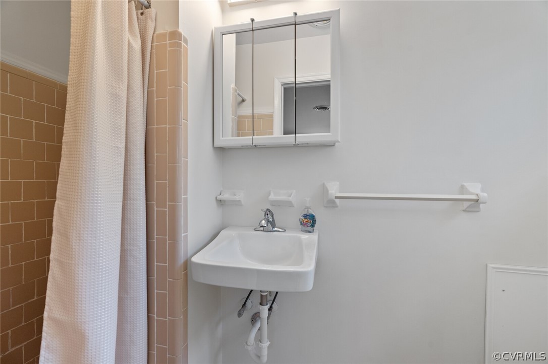 4541 Crossgate Road Chester, VA 23831 - Photo 34 of 47 a bathroom with a sink a mirror and a shower