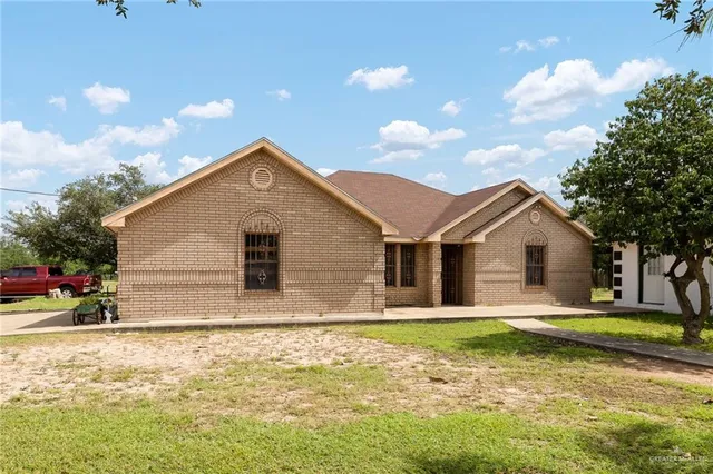 a front view of house with yard and trees around
