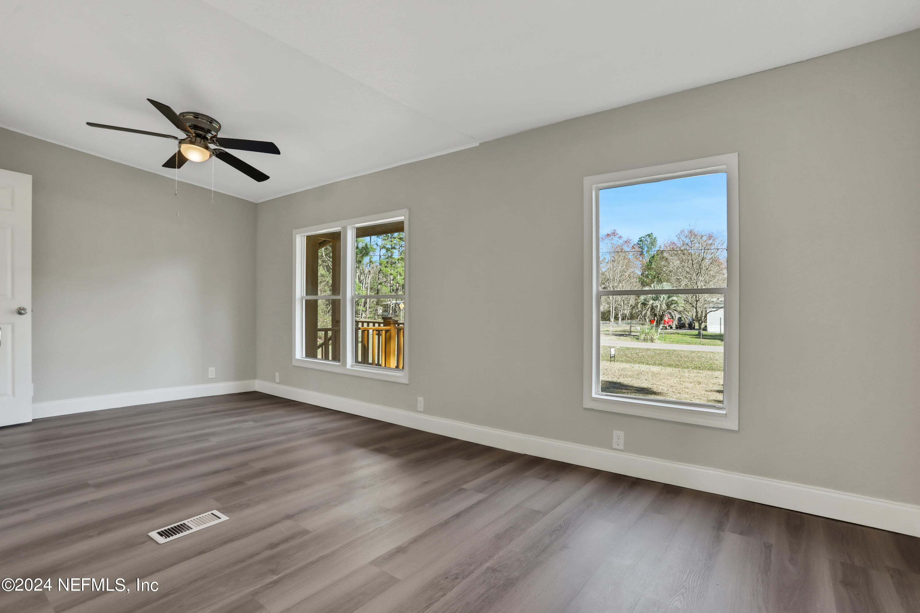 54057 Bea Road Callahan, FL 32011 - Photo 14 of 29 a view of an empty room with a window and wooden floor
