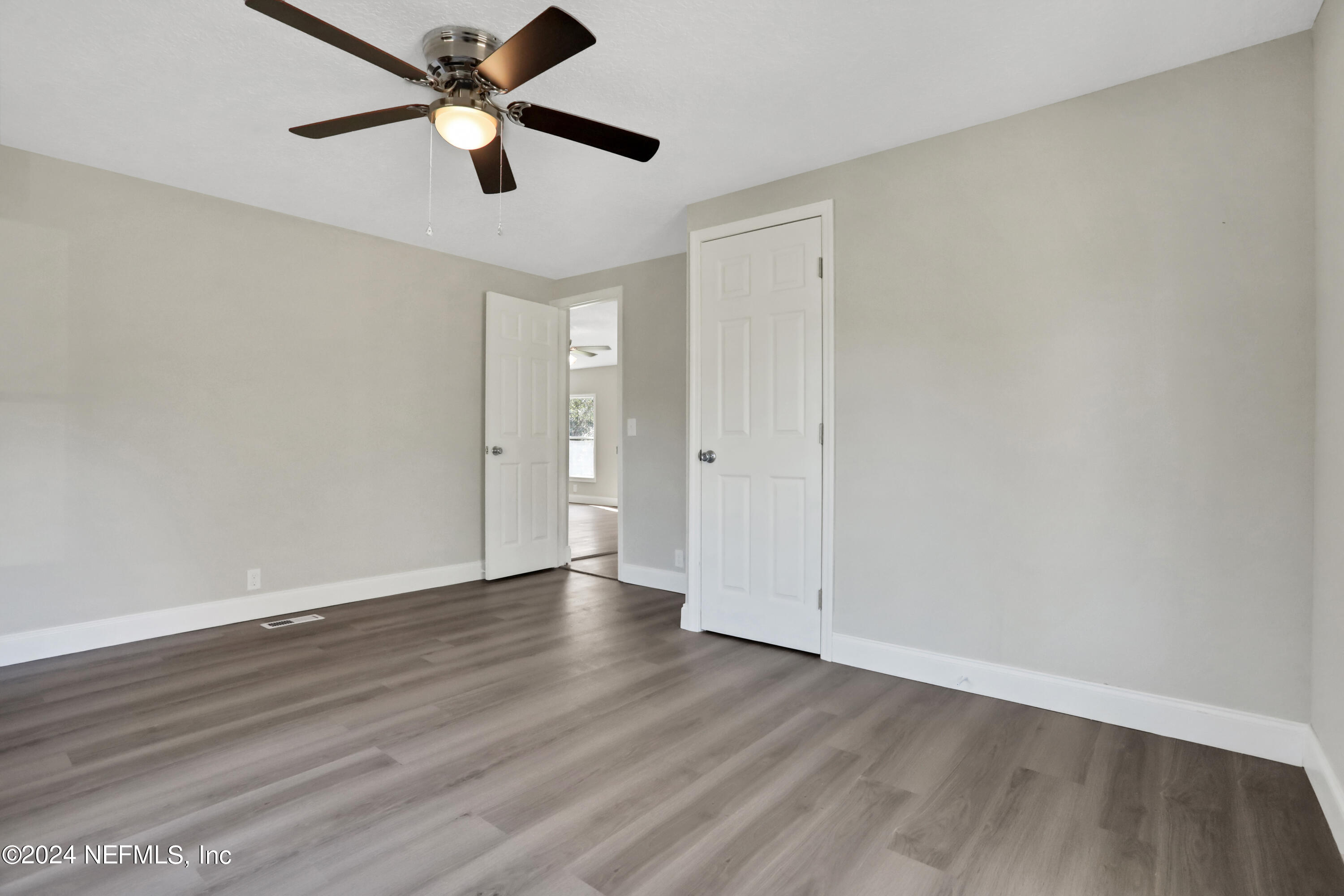 54057 Bea Road Callahan, FL 32011 - Photo 20 of 29 an empty room with wooden floor ceiling fan and windows