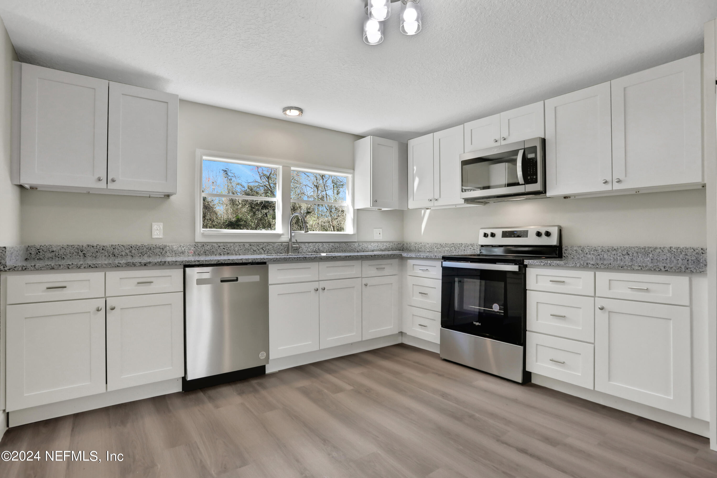 54057 Bea Road Callahan, FL 32011 - Photo 7 of 29 a kitchen with granite countertop white cabinets and white stainless steel appliances