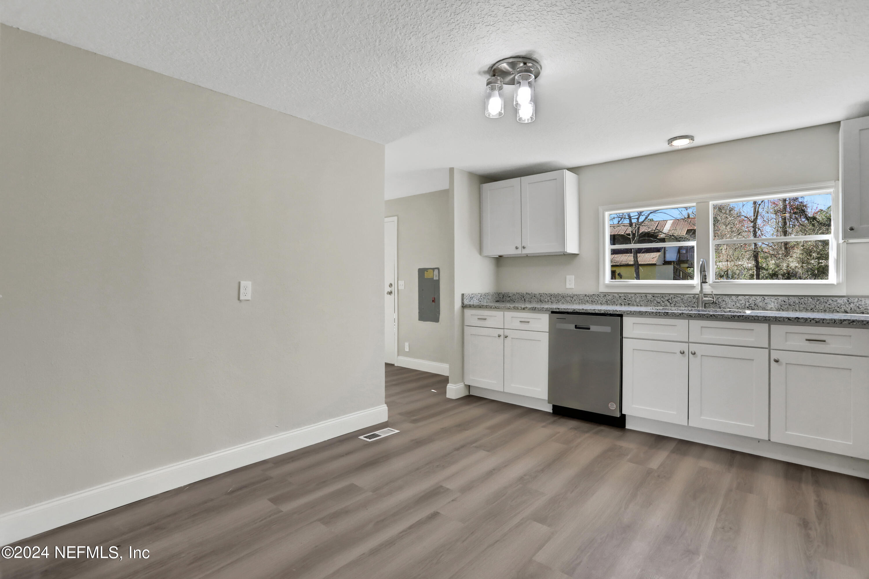 54057 Bea Road Callahan, FL 32011 - Photo 9 of 29 a kitchen with granite countertop white cabinets and white appliances