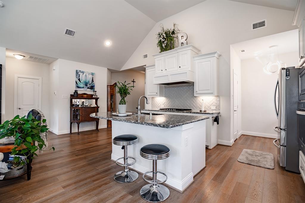 1213 Sea Island Road Aubrey, TX 76227 - Photo 19 of 36 Bright open living area with a clear view of the kitchen island—ideal for entertaining and family gatherings