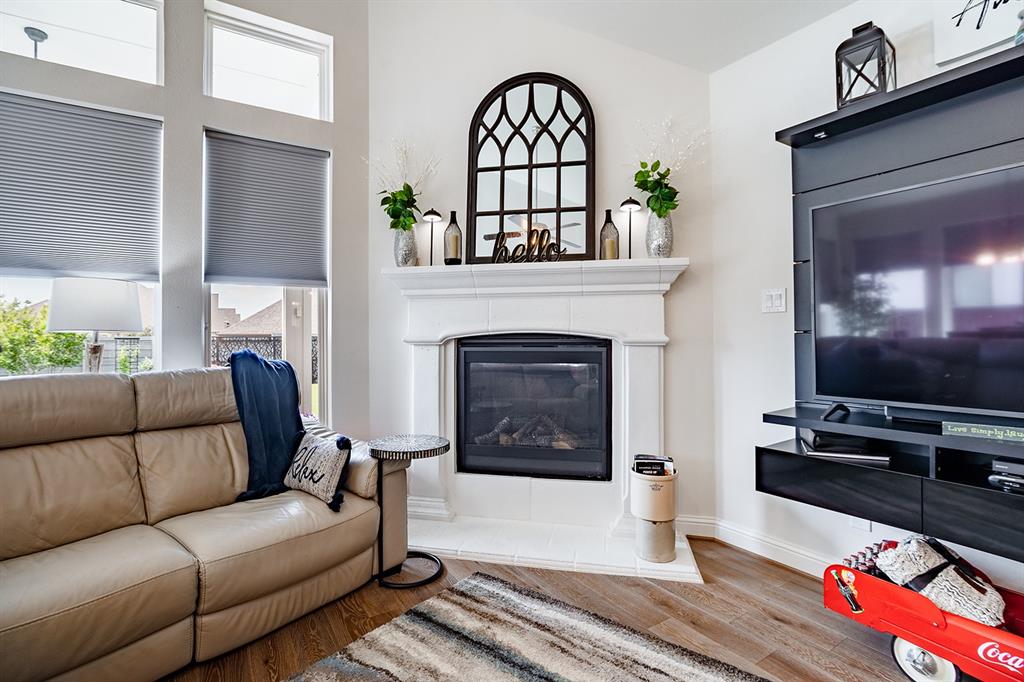 1213 Sea Island Road Aubrey, TX 76227 - Photo 21 of 36 Cozy living area featuring a gas fireplace with logs and a glass door in the living room