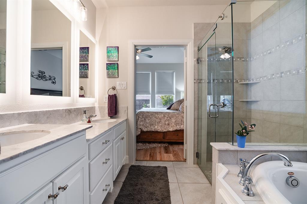 1213 Sea Island Road Aubrey, TX 76227 - Photo 26 of 36 Nicely lighted primary bathroom with dual sinks, including one raised for convenience and a stylish, functional layout. with frameless shower and walk-in closet